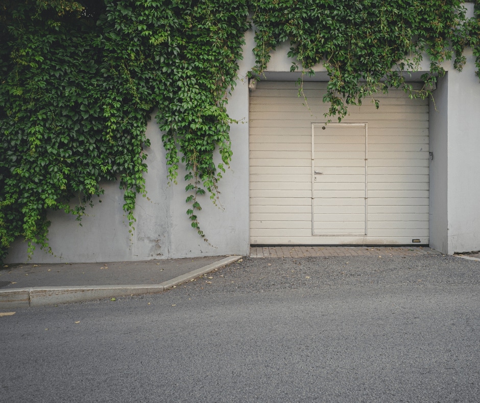 An asphalt driveway with a white garage door